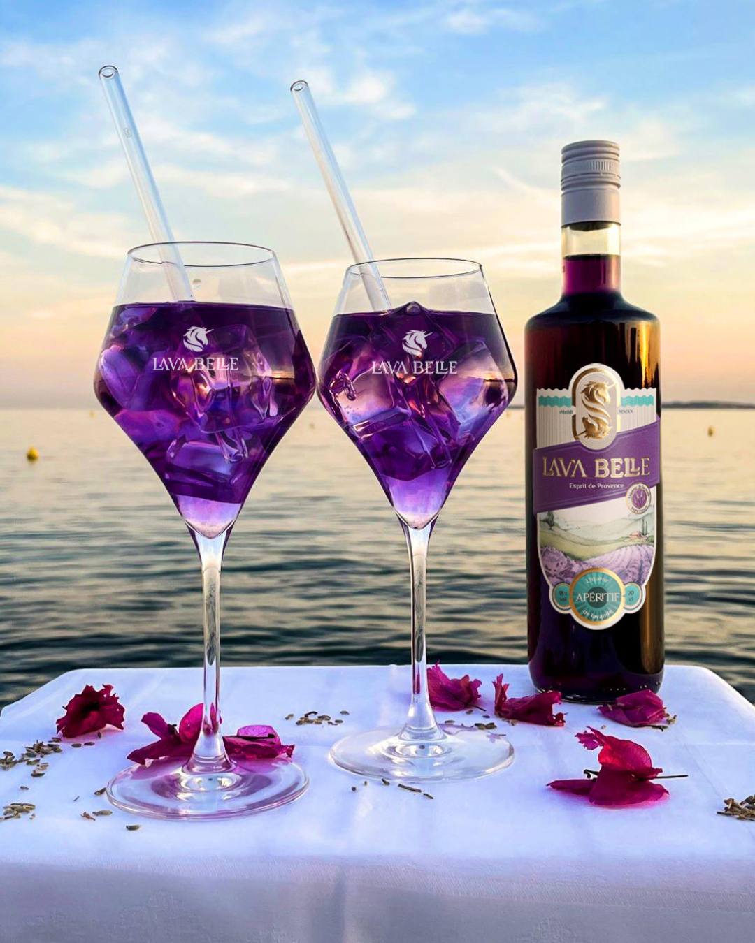 Serviervorschlag: zwei Apéritif-Gläser mit Lav'a Belle Spritz neben einer Flasche Lav'a Belle am Meer